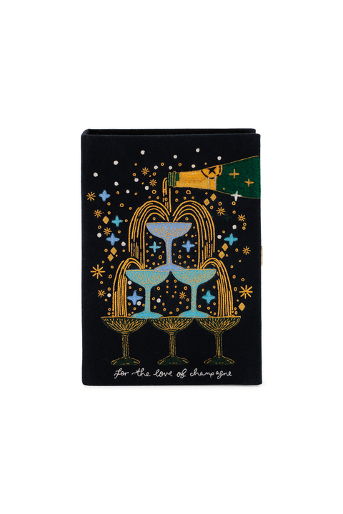 A black book clutch featuring a whimsical cocktail-themed illustration with three blue and gold martini glasses, a green and gold bottle, and white script text reading 'for the love of champagne' at the bottom.