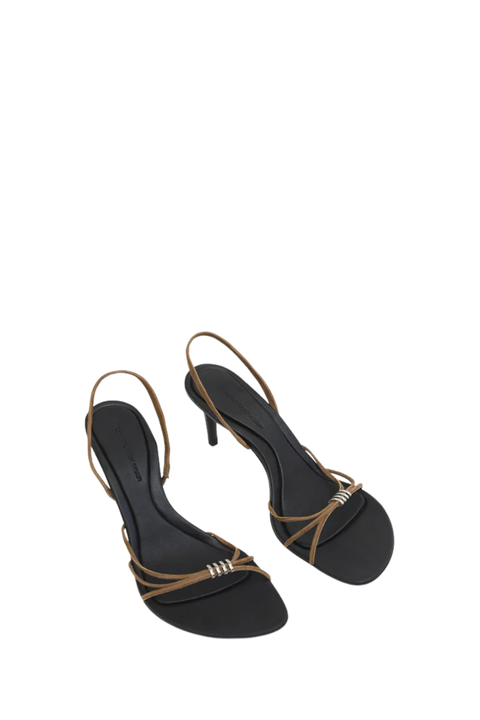 A pair of women's black slingback high heels with thin tan straps and a small silver metallic accent on the toe, shown against a plain white background.