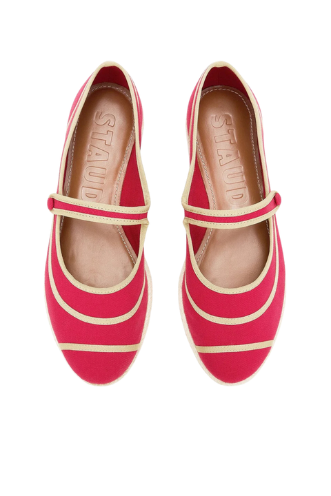 A pair of bright red Mary Jane flats with beige stripes and a beige insole, shown from a top-down view on a white background. The brand name 'STAUD' is embossed on the insole.