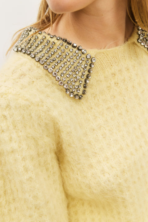 Detail shot of yellow, short, puff sleeve sweater with a crystal-embellished collar.