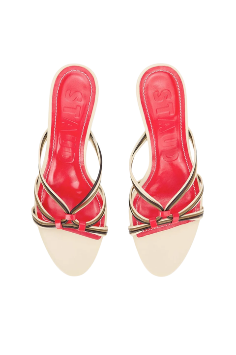 A pair of women's heeled mule sandals featuring a glossy red patent leather in-sole and thin metallic gold and black strappy details with red accents, shown against a plain white background.
