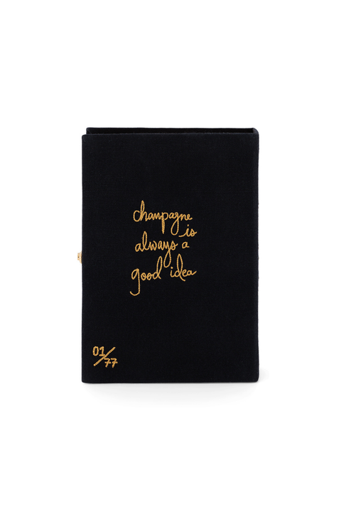 A black book clutch with gold foil script reading 'champagne is always a good idea' and a small gold '01/77' mark on the lower left, shown on a plain white background.
