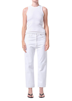 Person wearing a white sleeveless top and high-rise, straight leg, white jeans on a plain background from the front