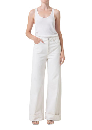 Person wearing a white tank top and white, high-rise, wide-leg pants on a white background
