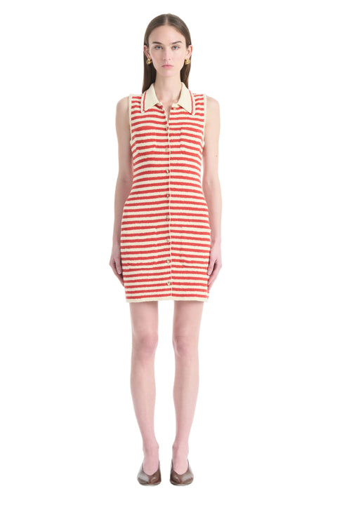 Woman wearing a red and white striped dress with gold buttons and collar on a white background