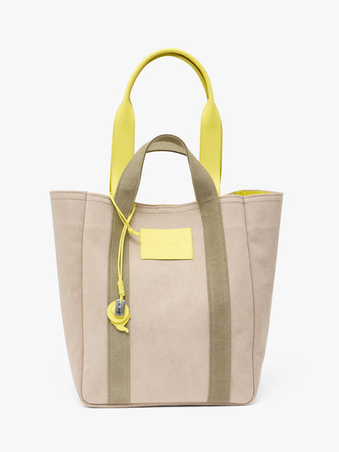 Beige canvas tote bag with green accents and yellow leather handles on a white background