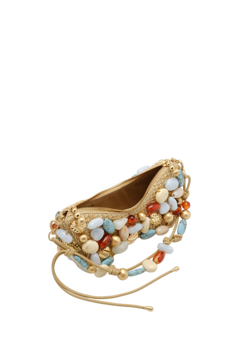 Gold handbag with colorful beads on a beige background with bag opened up.