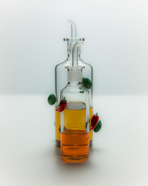 Chili oil bottle and olive oil bottle filled with oil.