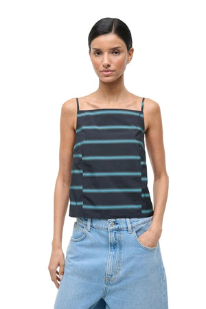Woman wearing a striped tank top and jeans on a white background