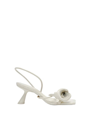 White high-heeled shoe with a lily on a white background
