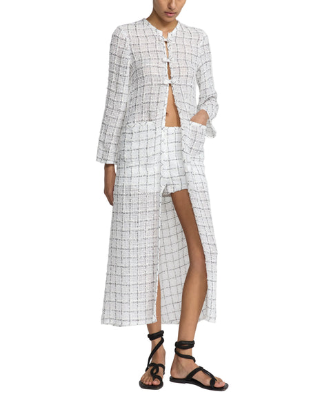 Person wearing a black and white checkered outfit with a slit skirt on a white background