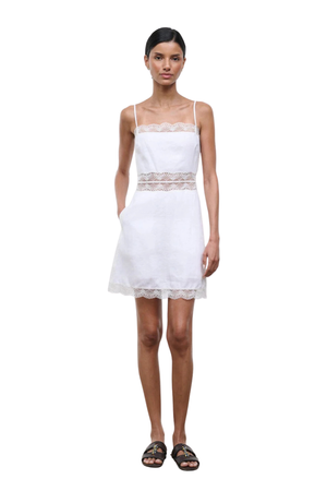 Woman wearing a white dress with lace details worn on a white background