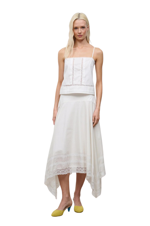 A woman wearing an ivory sleeveless top and a midi skirt set