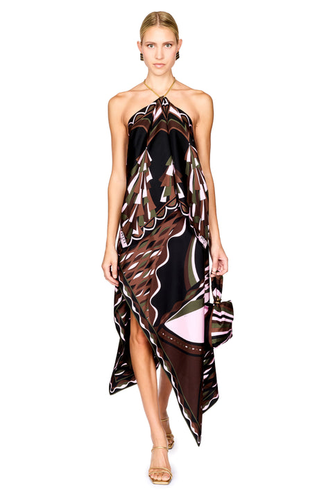 A model wearing a halter-neck, asymmetrical top and midi skirt with a brown, black, and pink abstract pattern, holding a matching handbag against a white background.