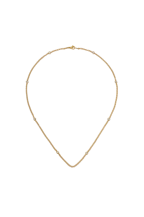 Gold necklace on a light beige background