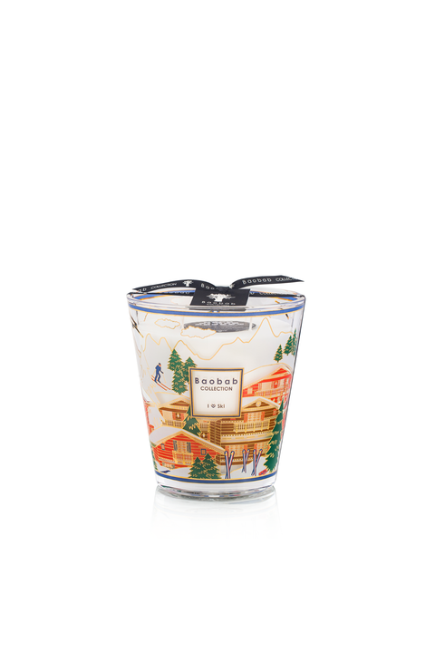 Candle with ski town design with black ribbon tie on top on white background.