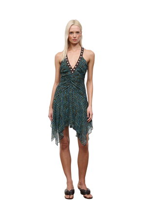 Woman wearing a patterned blue and brown dress with studs on a white background