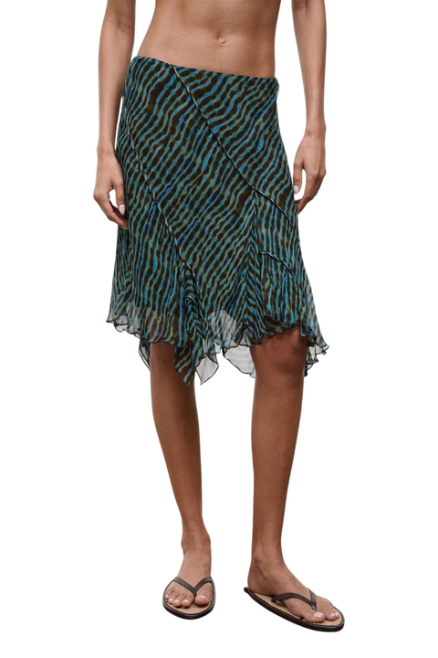 Close-up of a woman wearing a blue and brown patterned midi skirt on a white background