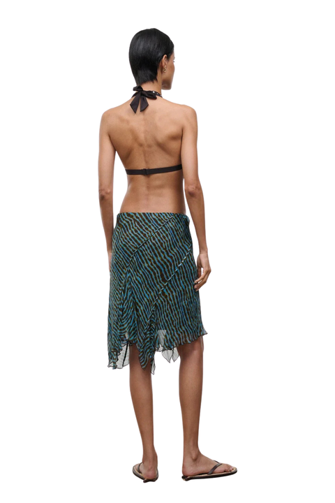 Woman wearing a blue and brown patterned midi skirt on a white background back angle