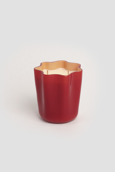 Two wicked candle in red flower shaped glass container.