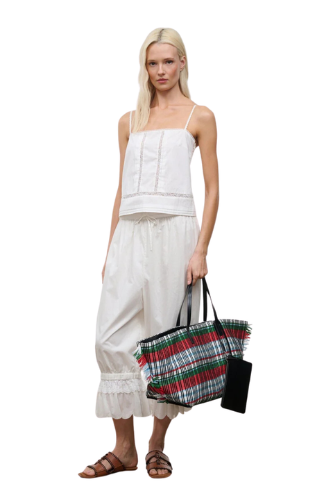 A woman wearing ivory bubble cropped trousers with an embroidered lace hem