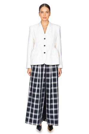 Woman wears cream hourglass shaped blazer with plaid pants.