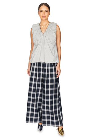 Women wears blue plaid pant skort with grey vest.