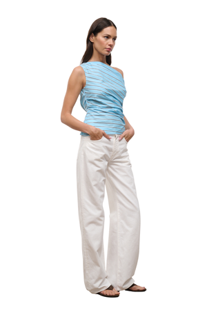 A woman modeling a sleeveless, one-shoulder ruched top in light blue and white stripes, paired with white wide-leg pants and brown sandals, set against a plain white background.