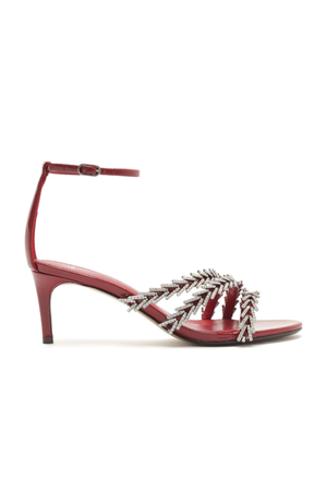 Red high-heeled sandal with ankle strap and with silver decorative elements on a white background