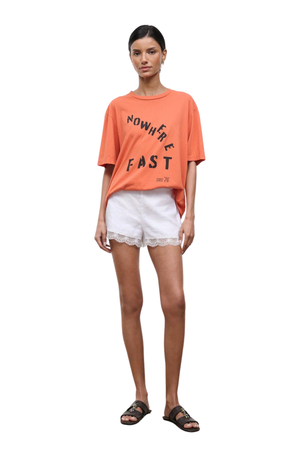Woman wearing white linen mini shorts with a lace trim front angle