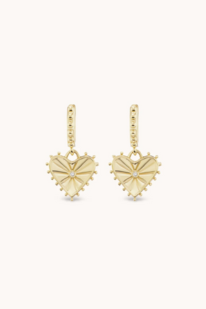 Heart shaped dangle earrings in yellow gold with small diamond in the center.