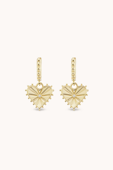Heart shaped dangle earrings in yellow gold with small diamond in the center.