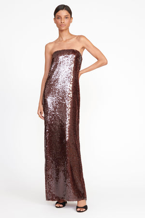 Woman in a brown sequin strapless maxi dress.