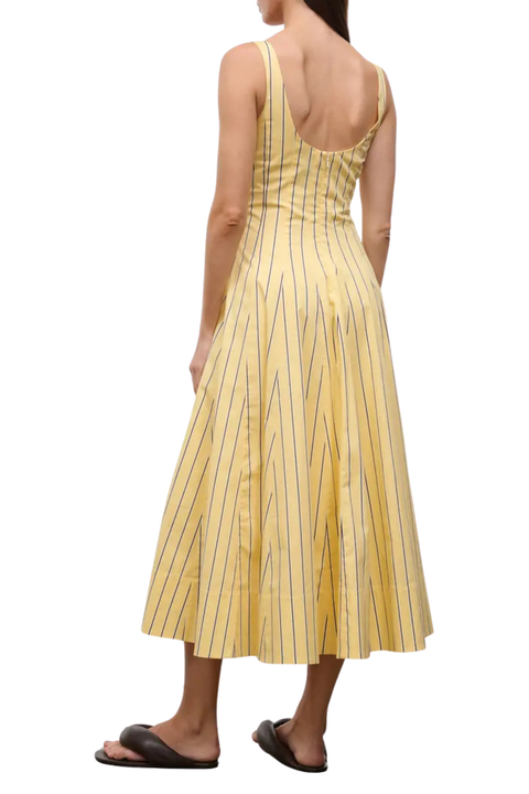 Woman wearing a long yellow striped dress with a red lobster design on a white background back angle