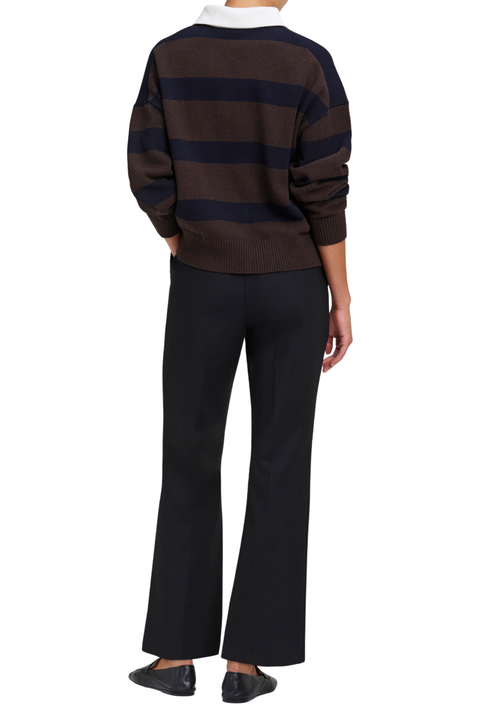 A model shown from the back wearing a brown and navy striped sweater with a white collar, paired with black wide-leg trousers and black shoes, on a solid white background.
