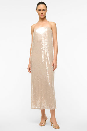 Woman wears cream sequin strapless midi dress.