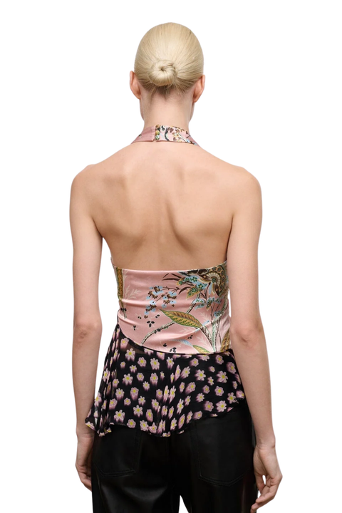 A woman viewed from the back wearing a halter-style top with a pink satin upper section, a black floral ruffled lower section, and black bottoms against a plain white background.