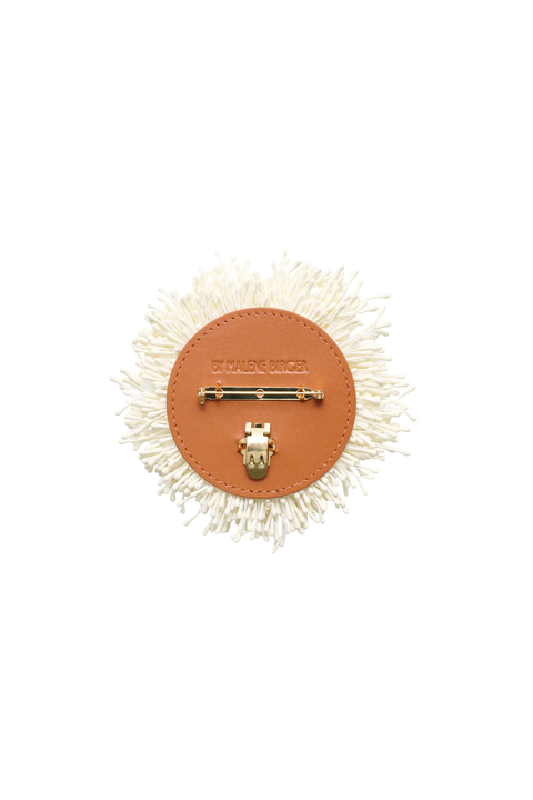 Back of an off-white brooch inspired by the petals of an anemone with a tube hinge closure.