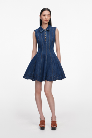 Woman wearing a blue denim collared mini dress on a white background