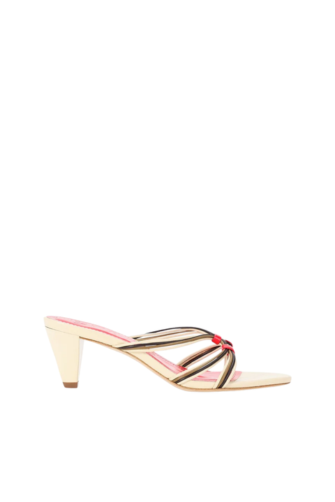 A single women's heeled mule sandal shown in side profile on a plain white background. The sandal has a light beige block heel and toe area, thin black and metallic gold crisscross straps across the instep, and a small red decorative accent at the center of the straps.