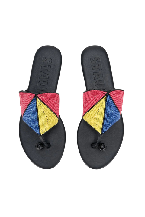 A pair of black slide sandals with colorful geometric woven straps in pink, yellow, and blue, shown from a top-down view on a white background.