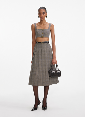 Woman wears brown check crop top with gold buttons and matching midi skirt.