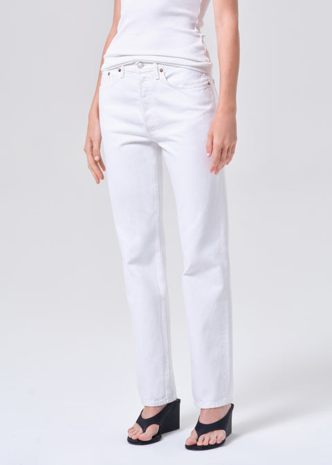 Person wearing a white t-shirt and white, mid-rise, straight-leg jeans on a white background facing forward off-center view 
