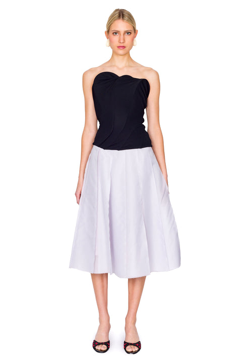 Woman styled in abstract black strapless top and purple midi skirt.