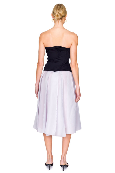 Back view of woman in black strapless top and purple skirt.