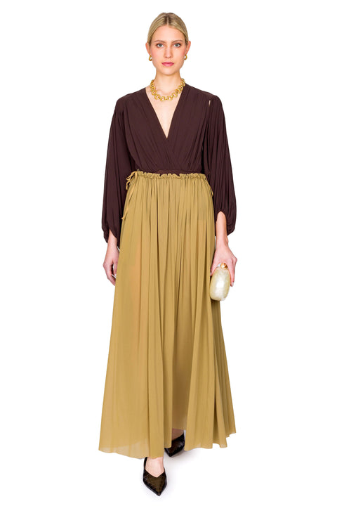 Model poses in brown long sleeve v-neck bodysuit and skirt.