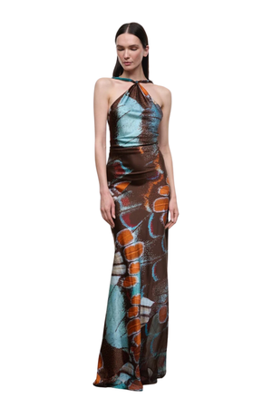 A model wearing a floor-length halter gown with an abstract print in brown, teal, and orange, set against a plain white background.