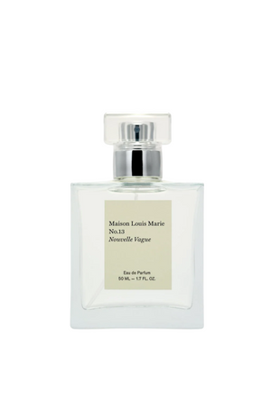 Square clear perfume bottle with a silver lid an beige square label. 
