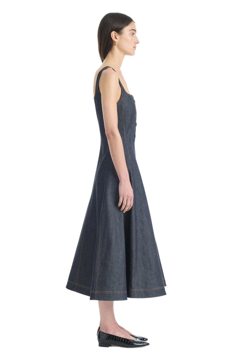 Side view of Woman wearing a dark denim dress on a white background