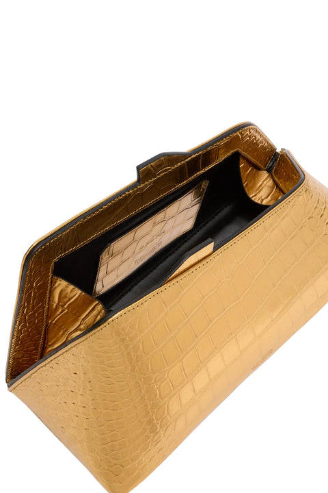 Gold clutch bag with crocodile texture on a light gray background
